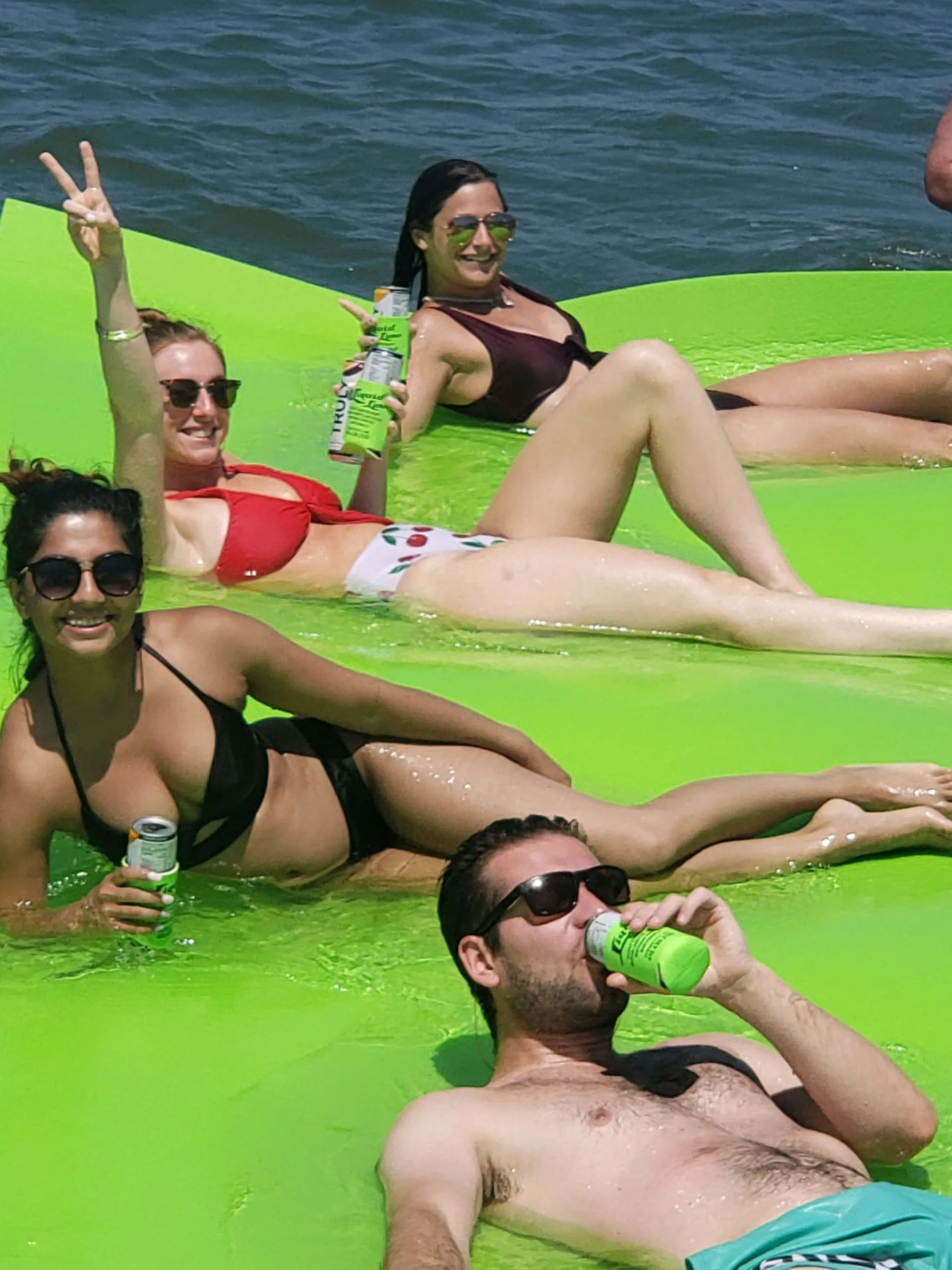 a group of people sitting next to a body of water
