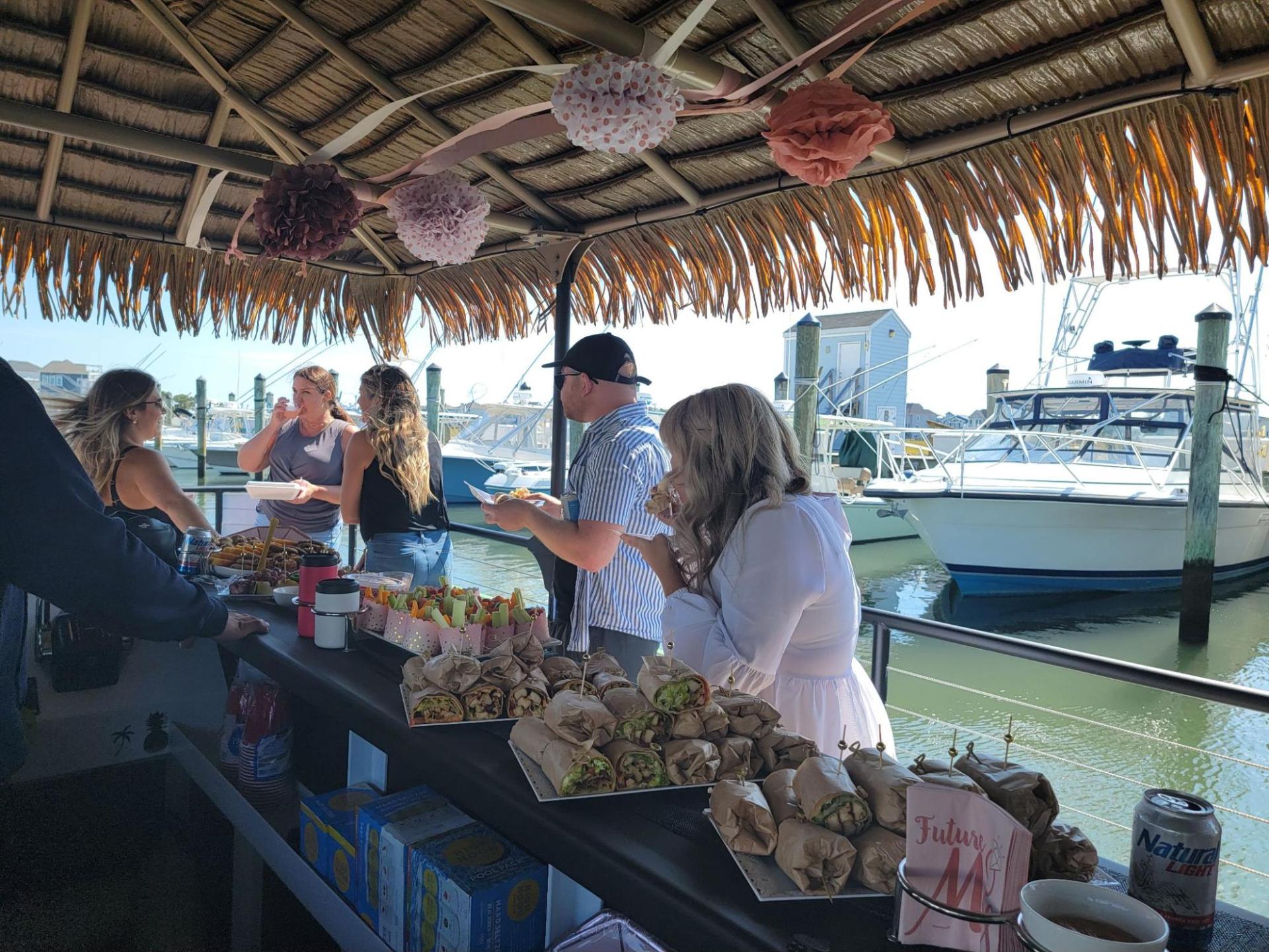 a group of people standing around a table full of food