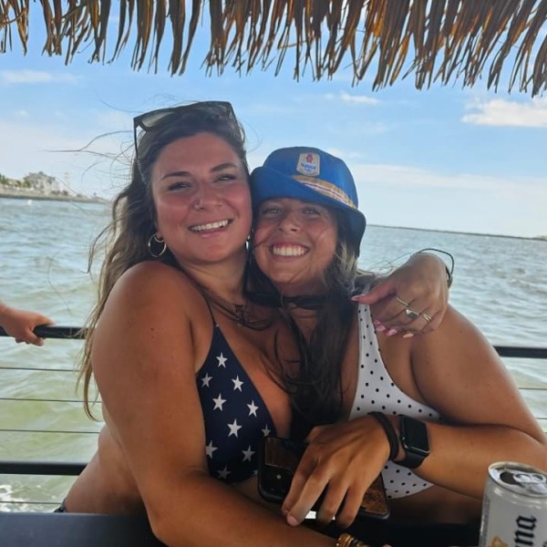 a woman sitting next to a body of water